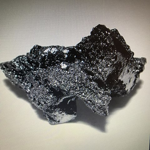 En la imagen vemos como se ve el renio en estado bruto. Tiene un color negro grisáceo.